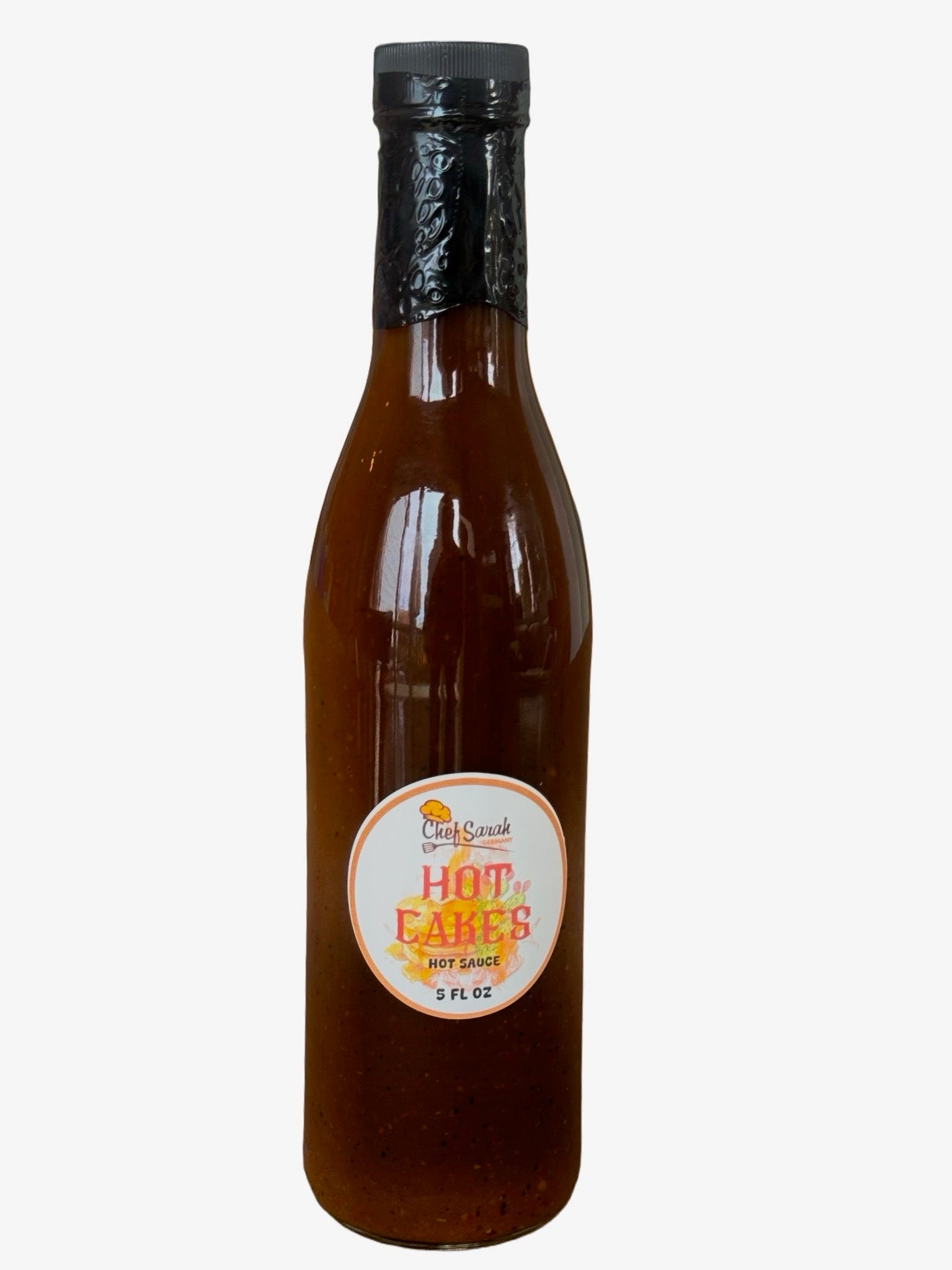 Bottle of Hot Cakes hot syrup sauce with a label on a white background