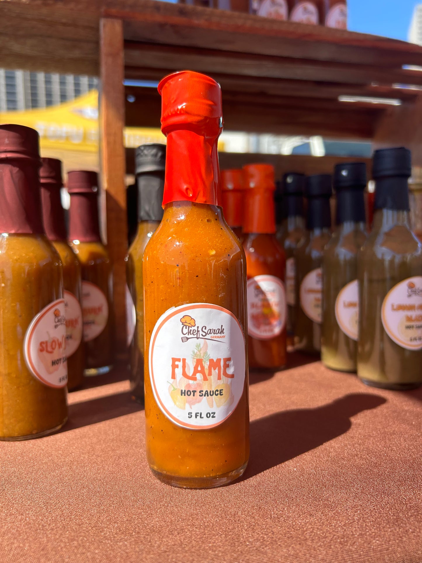 Bottle of 'Flame' hot sauce with a blurred background