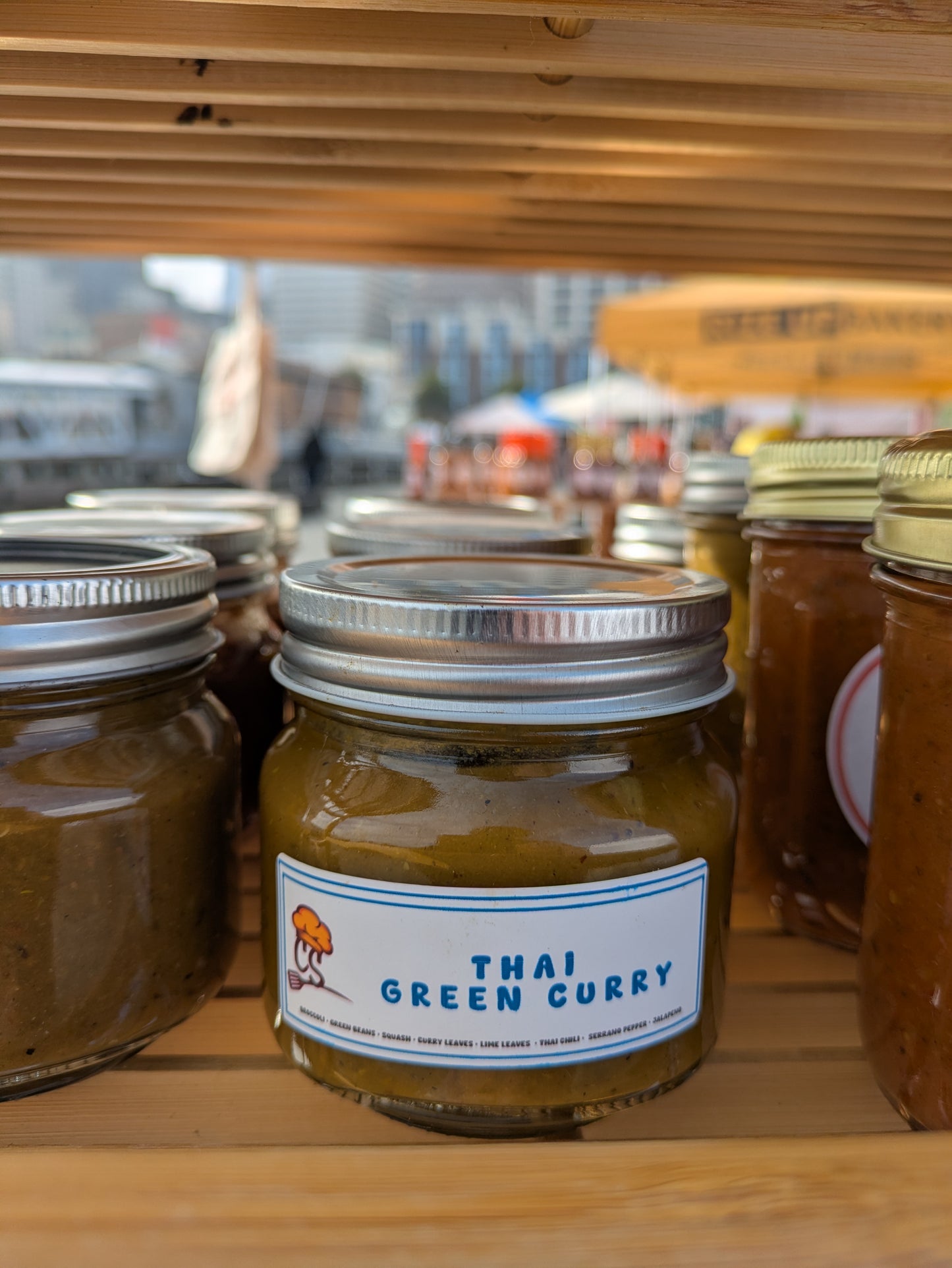 jars of sauces on a wooden rack