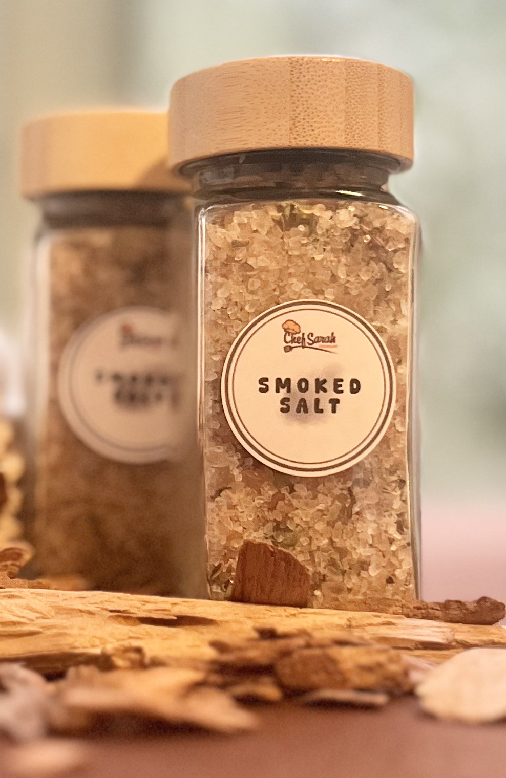 Jar of smoked salt with a wooden lid on a wooden surface