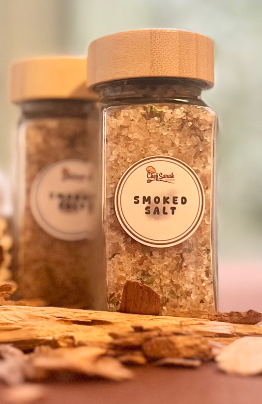 Jar of smoked salt with a wooden lid on a wooden surface