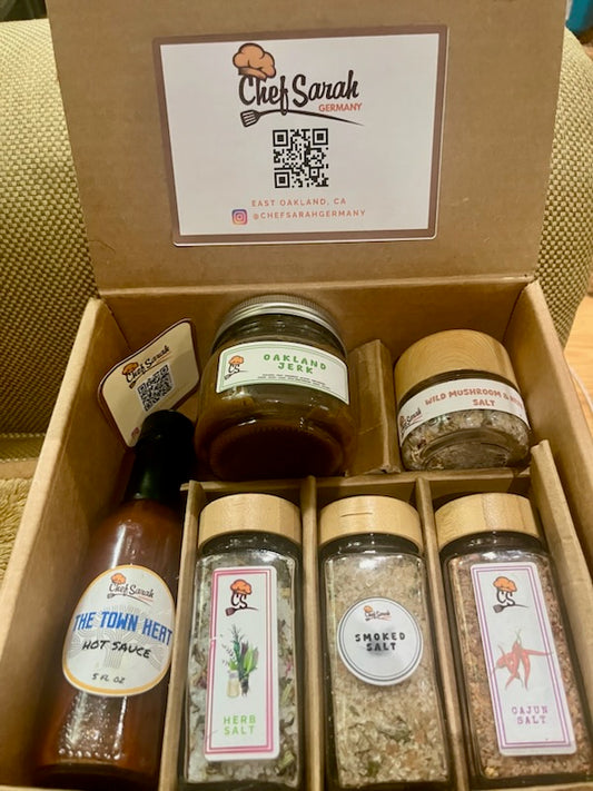 Box of Chef Sarah spice and herb set with various containers including hot sauce and salts.