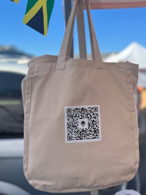 Beige tote bag with a QR code label hanging from a car window.